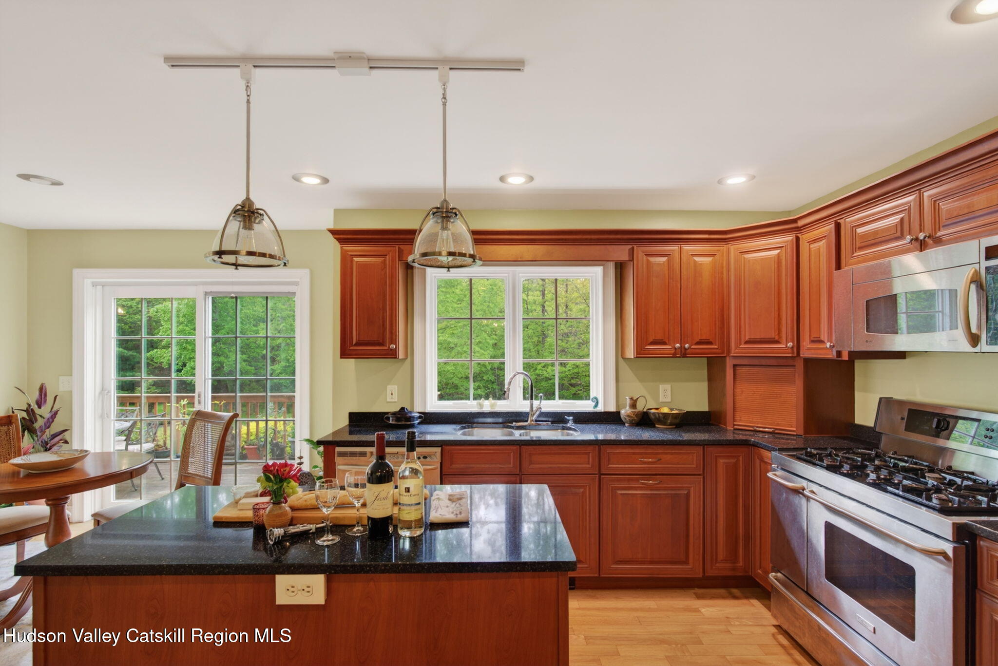 189 Bush Road Stone Ridge, NY 12484 - Photo 13 of 60 a kitchen with stainless steel appliances granite countertop a stove a sink and a granite counter tops with wooden floors
