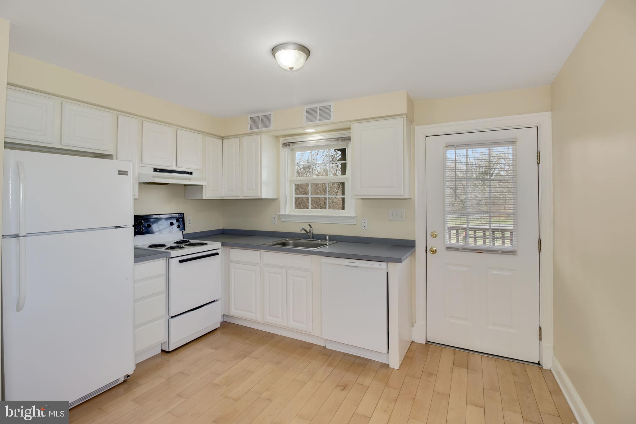 112 Main Street, Unit A New Windsor, MD 21776 - Photo 24 of 39 a kitchen with granite countertop white cabinets and white appliances