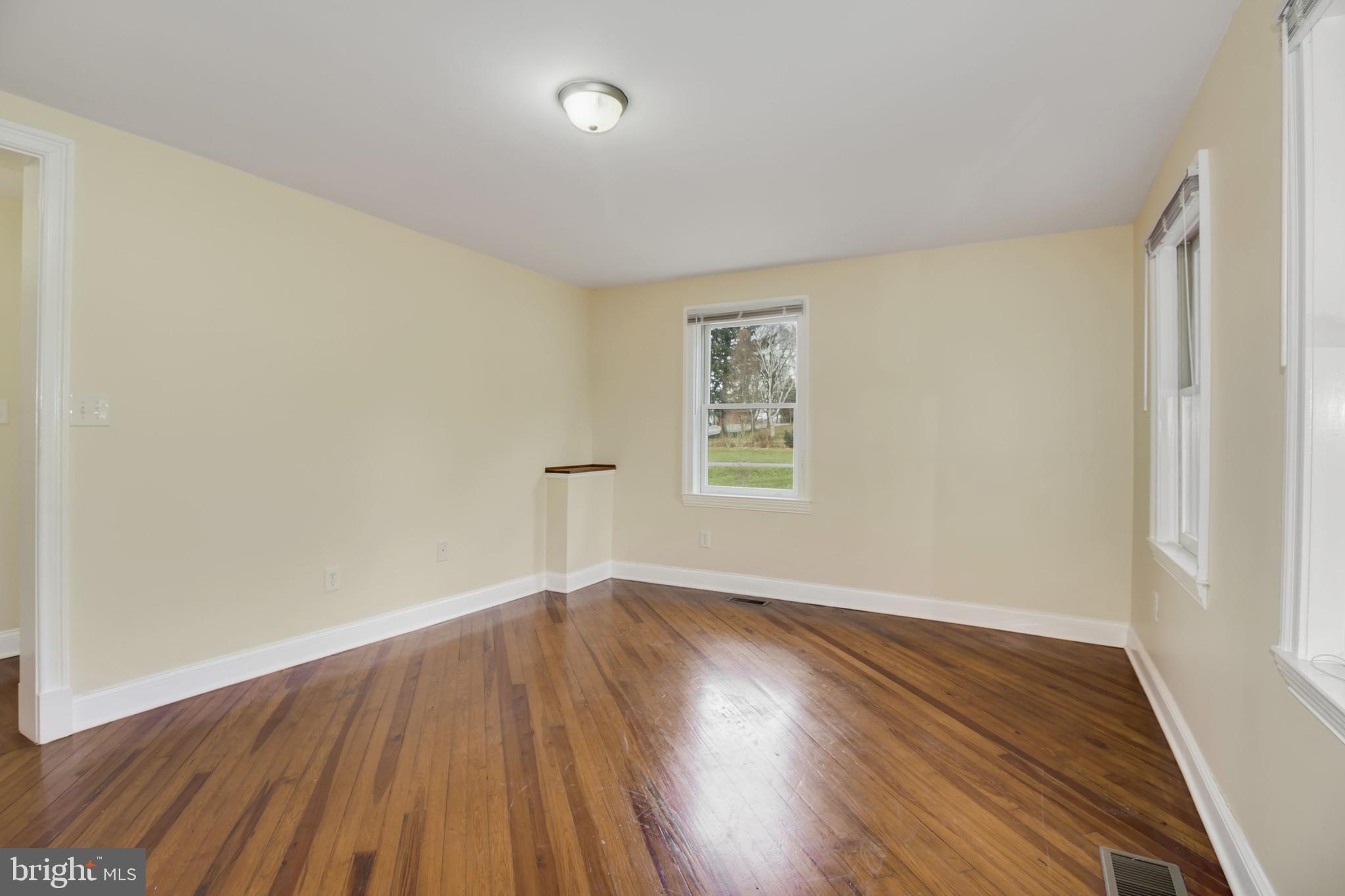 112 Main Street, Unit A New Windsor, MD 21776 - Photo 27 of 39 an empty room with wooden floor and windows