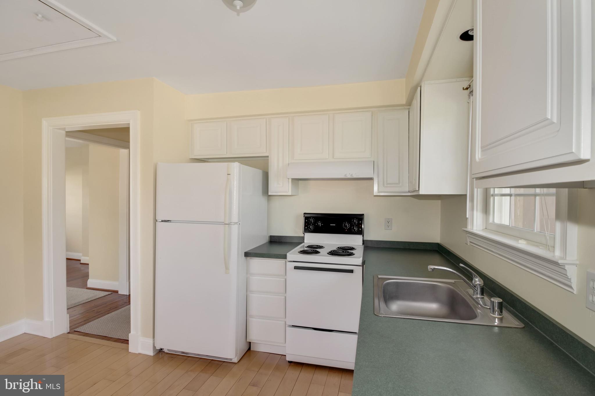 112 Main Street, Unit A New Windsor, MD 21776 - Photo 7 of 39 a kitchen with white cabinets and white appliances