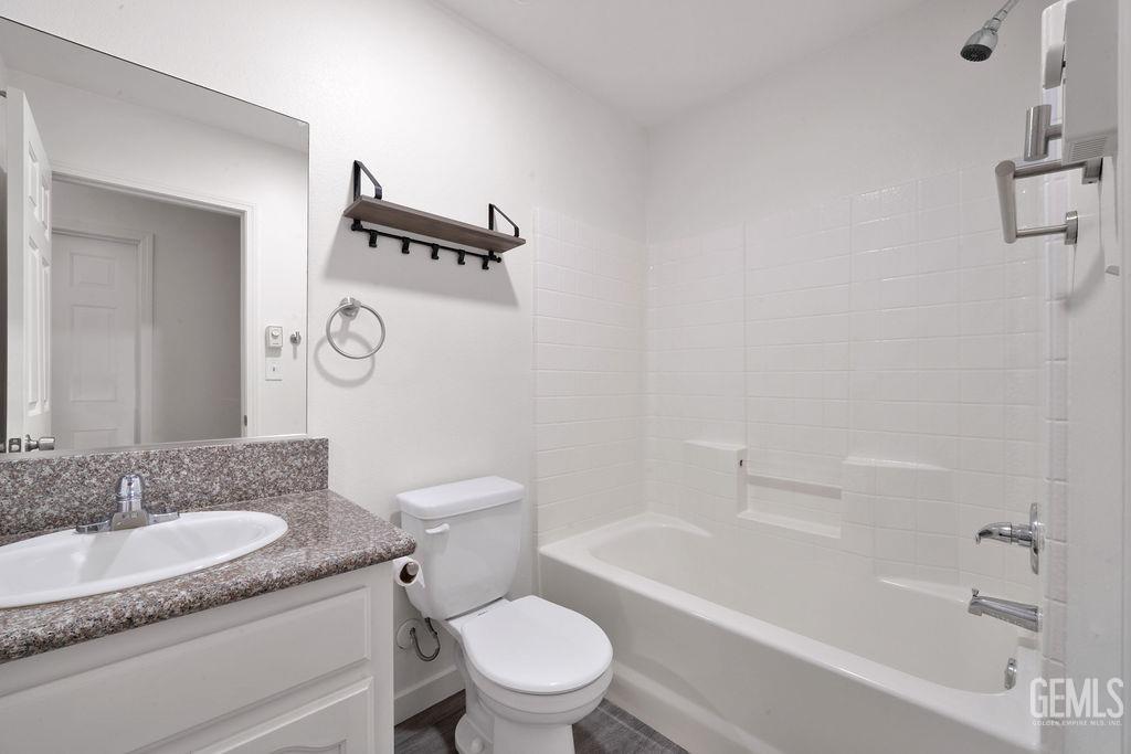 Undisclosed Address McFarland, CA 93250 - Photo 15 of 35 a bathroom with a granite countertop sink toilet mirror and bathtub