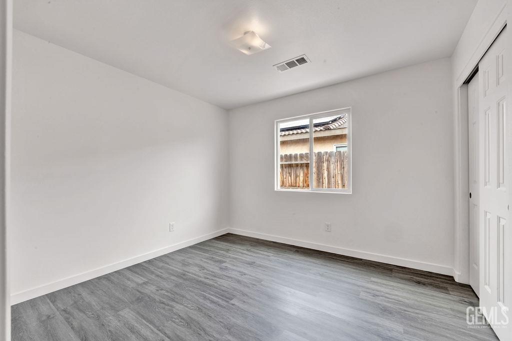 Undisclosed Address McFarland, CA 93250 - Photo 18 of 35 an empty room with wooden floor and windows