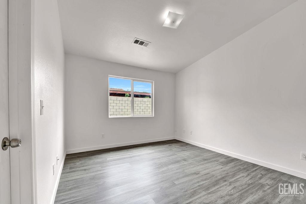 Undisclosed Address McFarland, CA 93250 - Photo 22 of 35 an empty room with wooden floor and windows