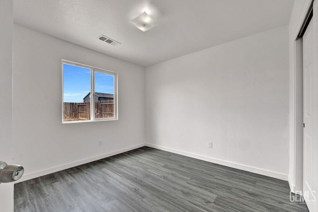 Undisclosed Address McFarland, CA 93250 - Photo 27 of 35 an empty room with wooden floor and windows