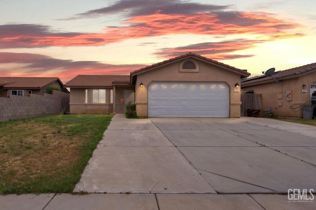 Undisclosed Address McFarland, CA 93250 - Photo 3 of 35 a front view of a house with a yard and garage