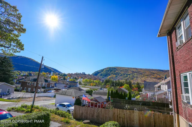 a view of a houses with a table and chairs under an umbrella