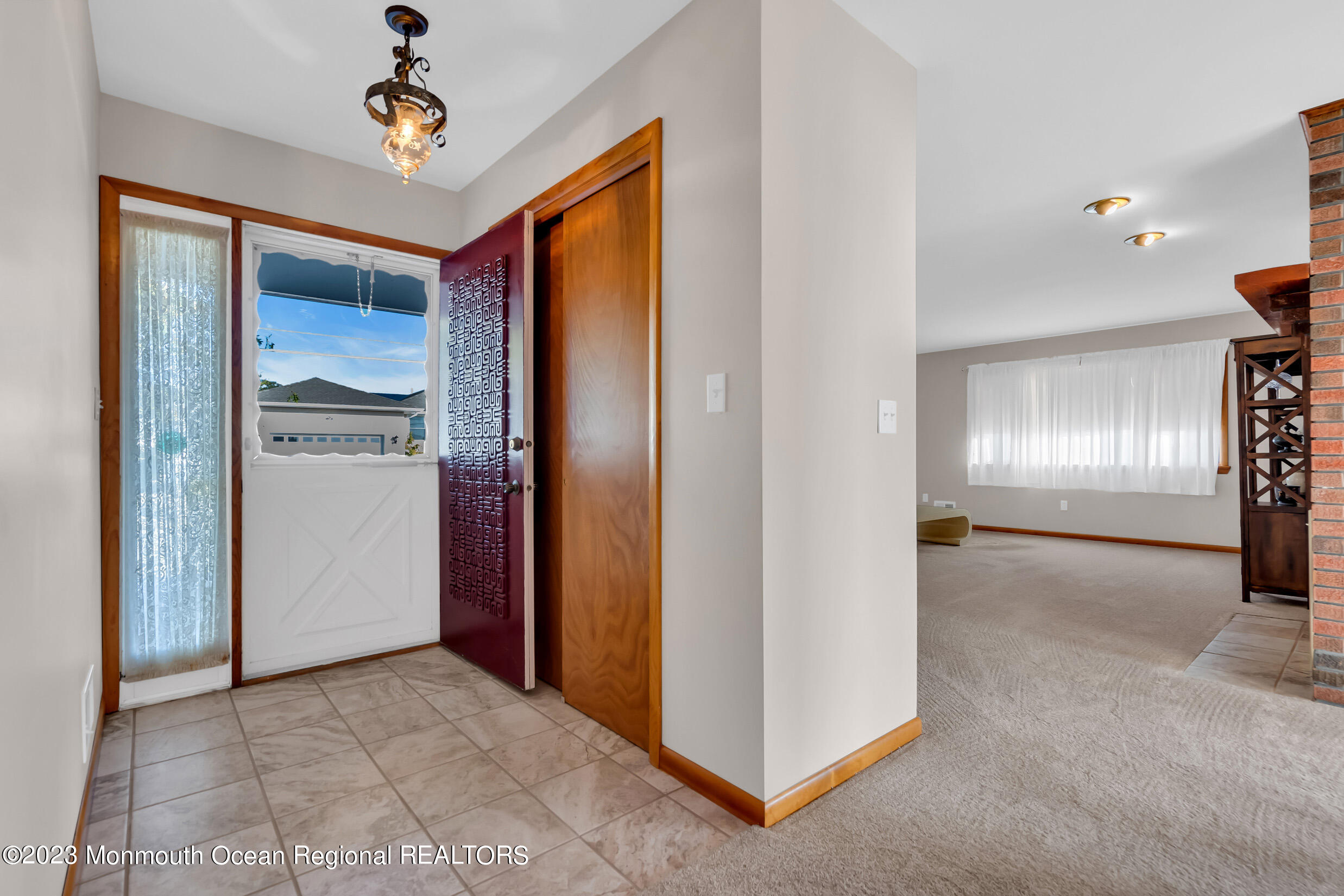 2 Channel Road Toms River, NJ 08753 - Photo 8 of 57 a view of a hallway with a refrigerator and a chandelier