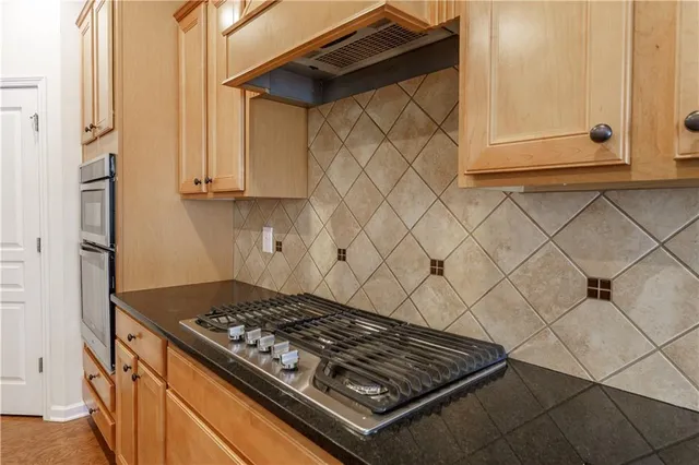 a metallic refrigerator freezer sitting in a kitchen