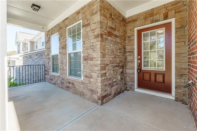 an empty room with wooden floor fireplace and windows