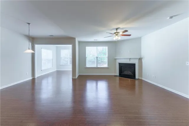wooden floor fireplace and windows in an empty room