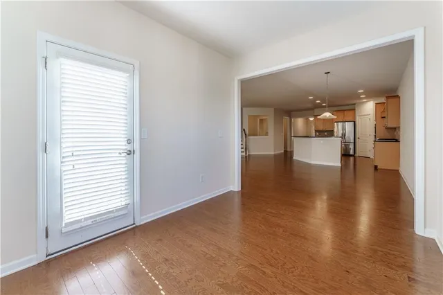 a view of a kitchen with a kitchen island stainless steel appliances wooden floor and a view of kitchen
