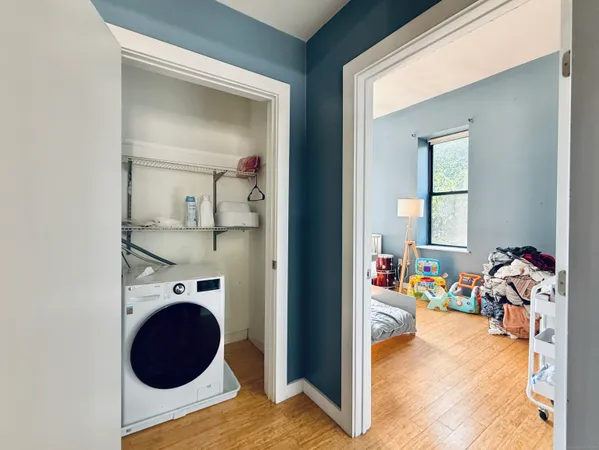 a view of a hallway to a dining room with wooden floor and a chandelier