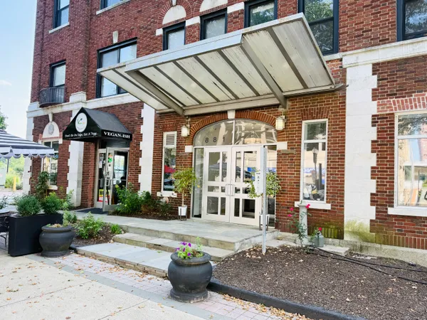 a view of a house with a potted plants and a table and chairs