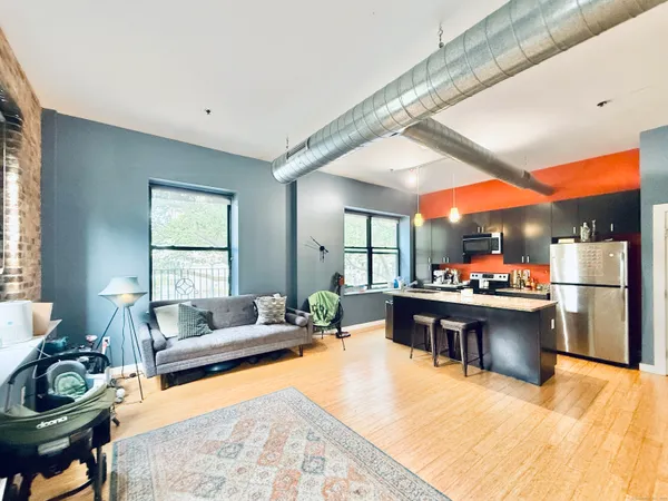 a living room with furniture a fireplace and a large window