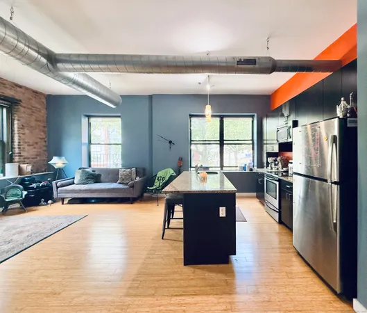 a kitchen with stainless steel appliances granite countertop a refrigerator a stove a sink dishwasher and a dining table with wooden floor