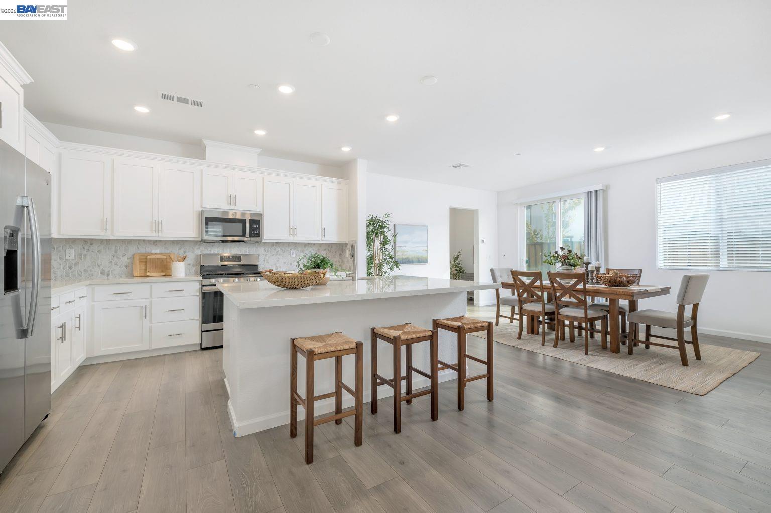 30 Cypress Way Pittsburg, CA 94565 - Photo 4 of 30 a kitchen with stainless steel appliances granite countertop a stove a sink a microwave a dining table and chairs with wooden floor