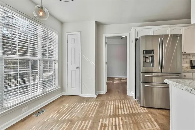 an empty room with wooden floor ceiling fan and windows