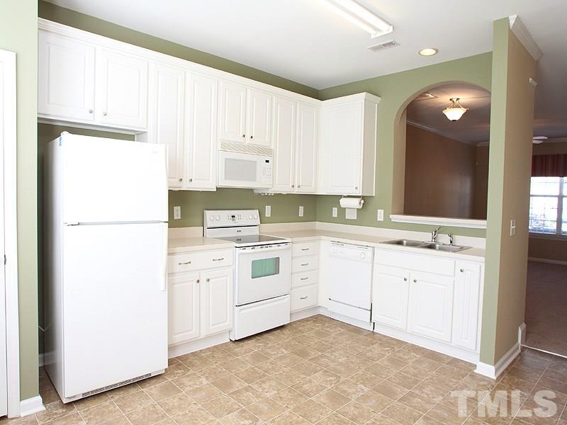 8458 Reedy Ridge Lane Raleigh, NC 27613 - Photo 6 of 12 a kitchen with white cabinets and white appliances