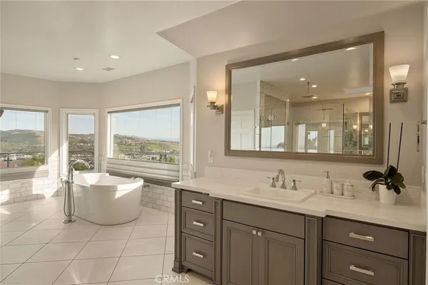 a spacious bedroom with a large bed and a chandelier