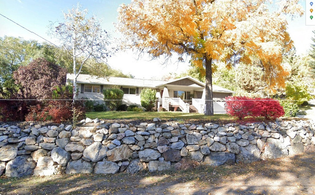 1360 Carterville Road Orem, UT 84097 - Photo 39 of 41 Stone retaining wall with established landscaping, mature trees, and a front porch entry