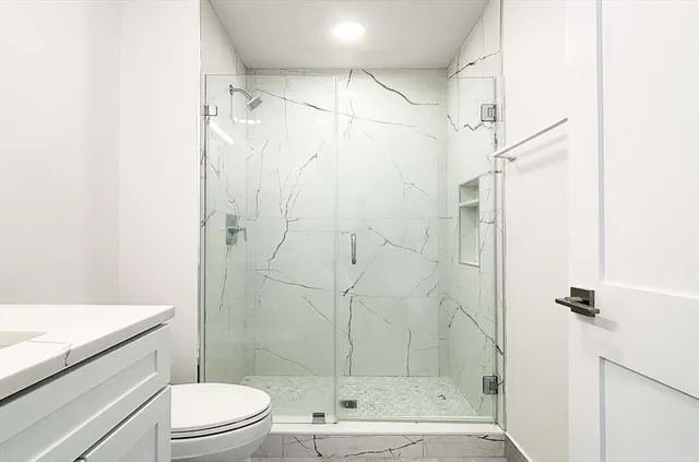 a bathroom with a shower a toilet and sink