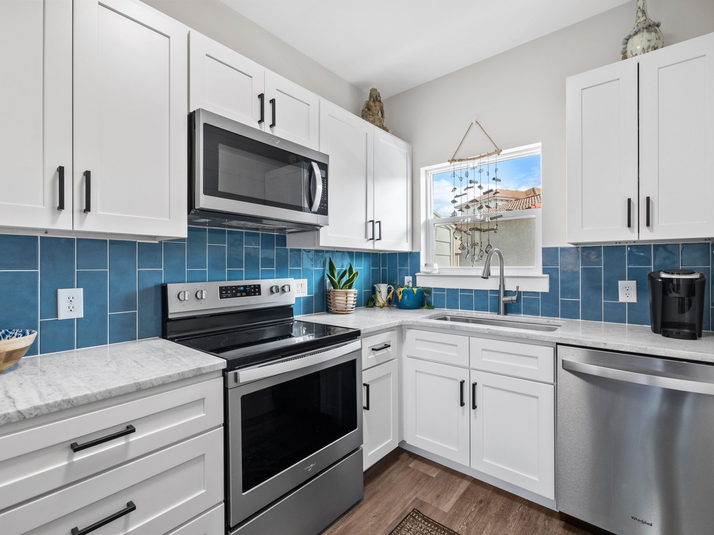 209 Blue Mountain Road, Unit 302 Santa Rosa Beach, FL 32459 - Photo 11 of 40 a kitchen with cabinets stainless steel appliances and wooden floor