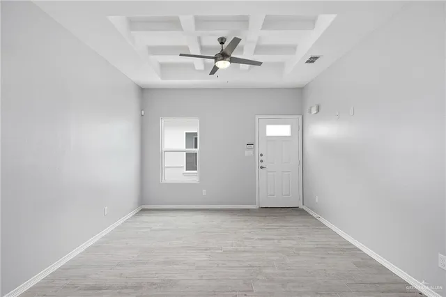 an empty room with a ceiling fan and window