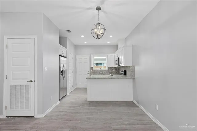 a view of a kitchen with a sink a refrigerator and window