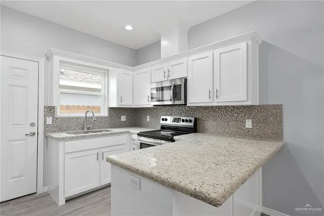 a kitchen with stainless steel appliances granite countertop a sink stove and cabinets