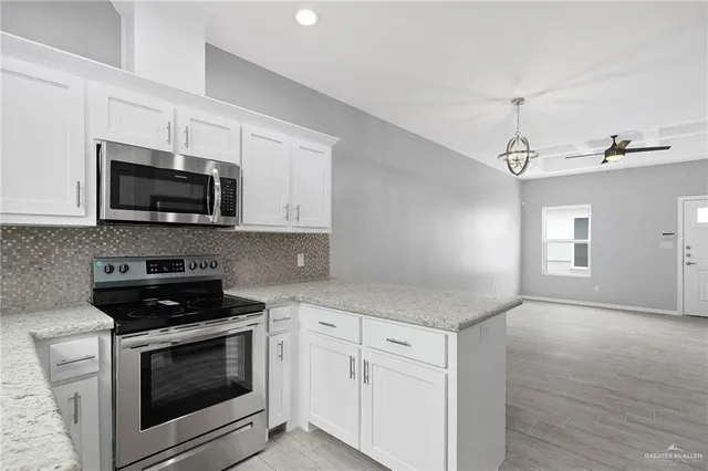a kitchen with white cabinets and black appliances