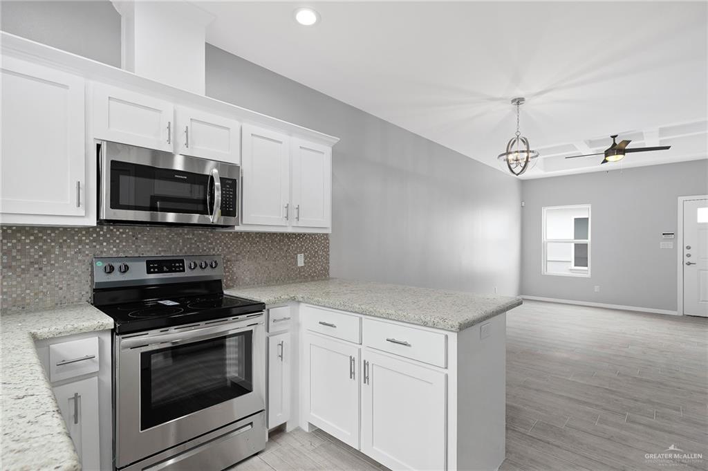 1908 Stauffers Street, Unit 1 Weslaco, TX 78596 - Photo 5 of 14 a kitchen with white cabinets and black appliances