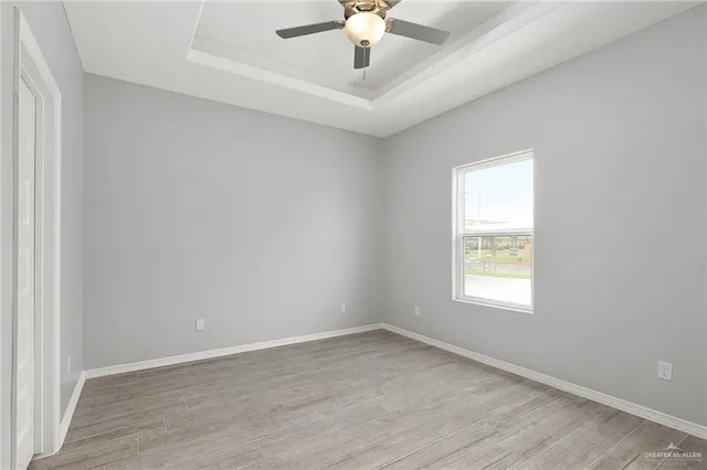 an empty room with a window and a ceiling fan