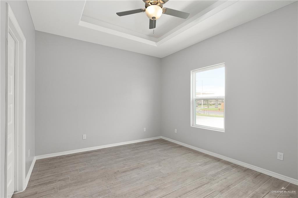 1908 Stauffers Street, Unit 1 Weslaco, TX 78596 - Photo 7 of 14 an empty room with a window and a ceiling fan