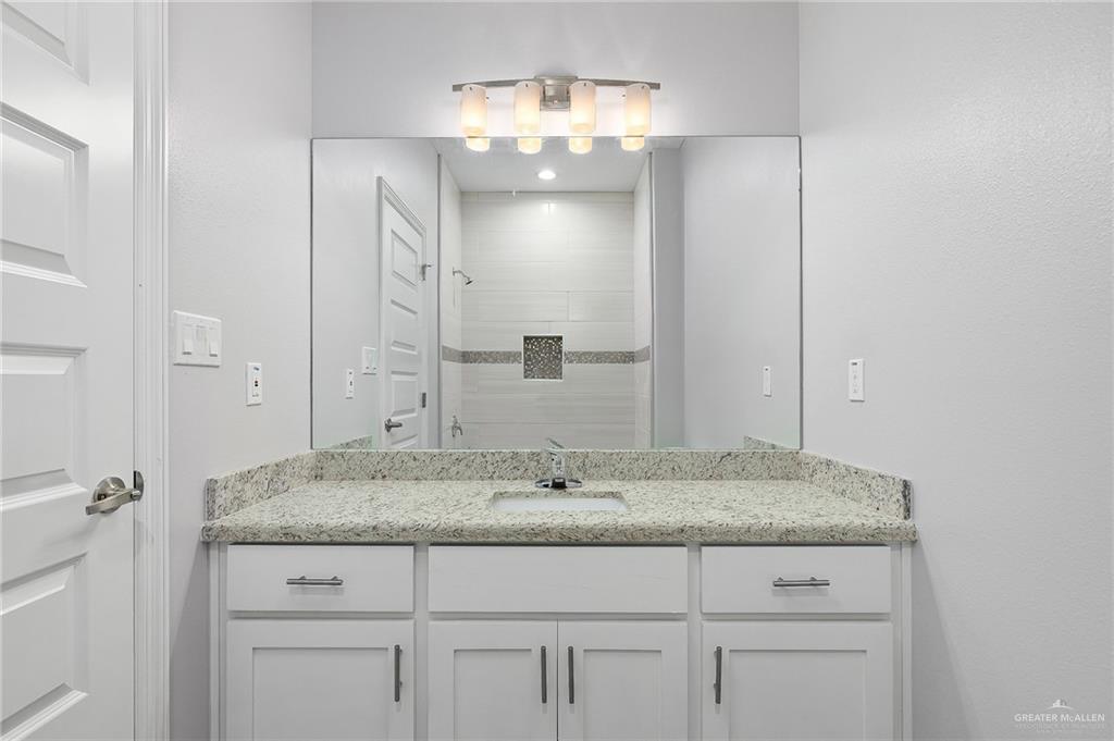 1908 Stauffers Street, Unit 1 Weslaco, TX 78596 - Photo 8 of 14 a bathroom with a granite countertop sink and a mirror