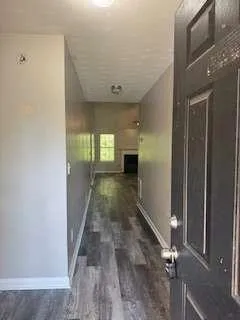 a view of an empty room with a fireplace and a window