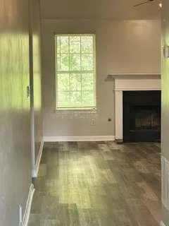 a view of an empty room with a fireplace and a window