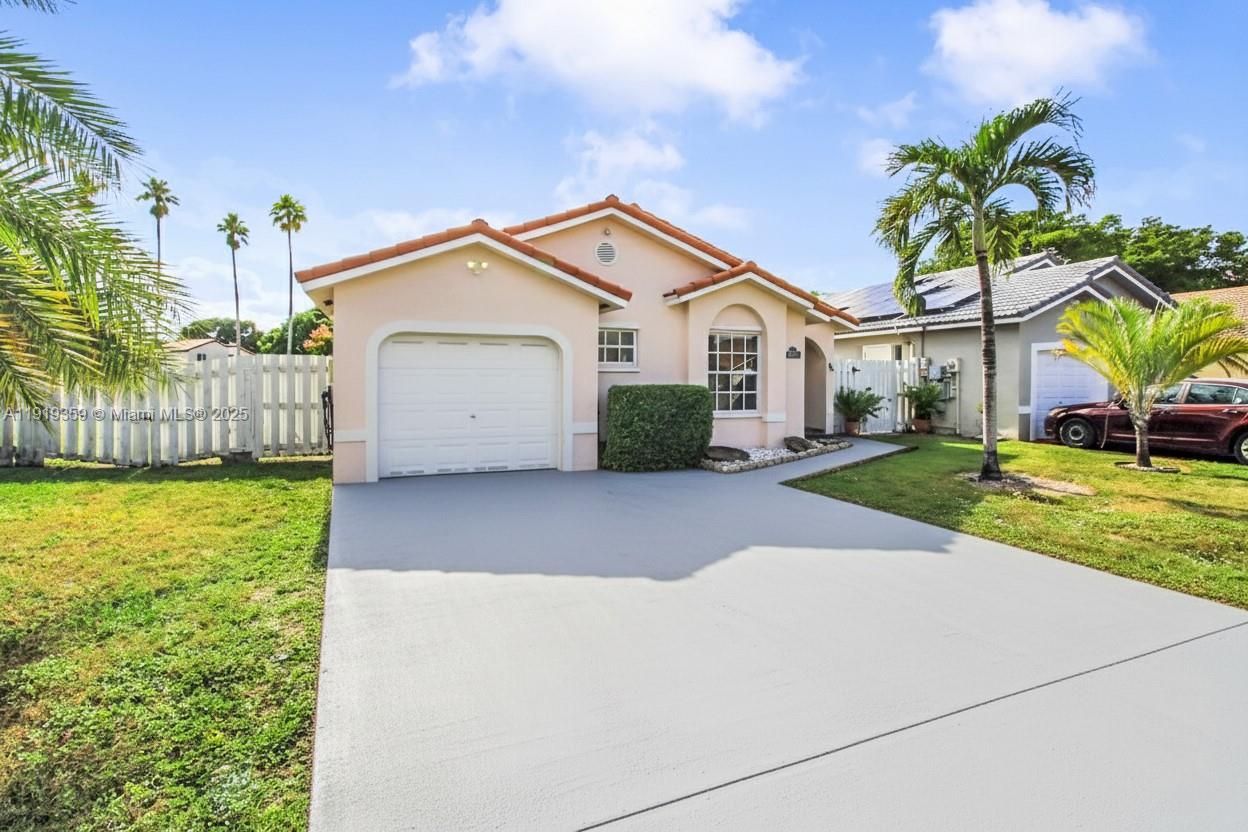 6122 Northwest 181st Terrace Circle West Hialeah, FL 33015 - Photo 2 of 28 a view of a white house next to a yard with big trees