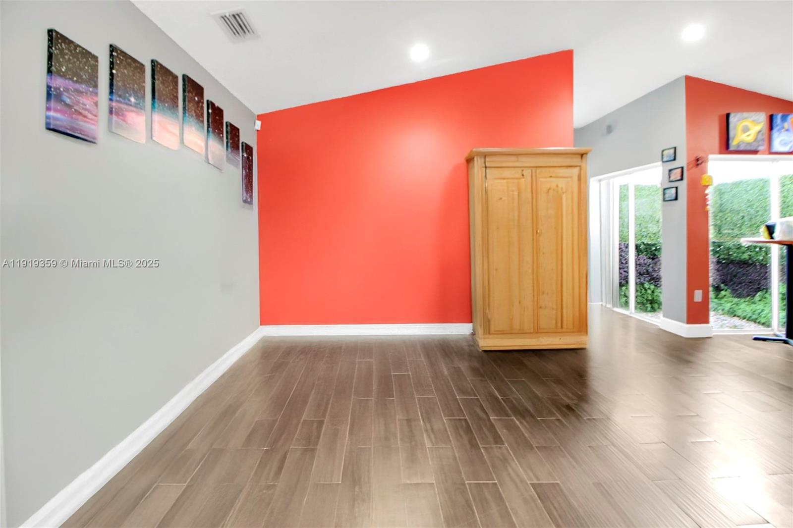 6122 Northwest 181st Terrace Circle West Hialeah, FL 33015 - Photo 5 of 28 a view of an empty room with wooden floor and a window