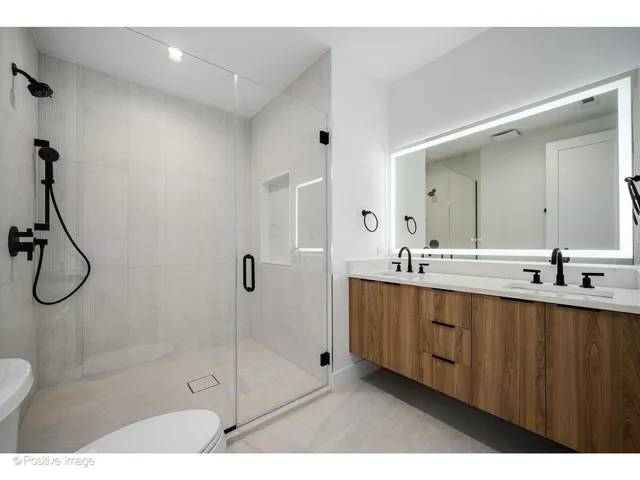 a bathroom with a shower a sink and mirror