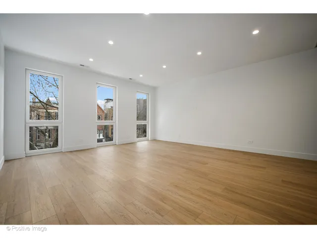 a view of an empty room with wooden floor and closet