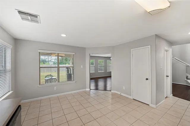 a view of an empty room with window and cabinet