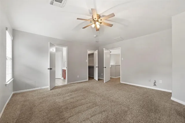a view of an empty room with a ceiling fan