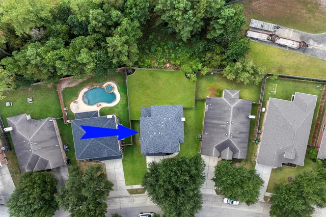 an aerial view of a house with outdoor space and a swimming pool