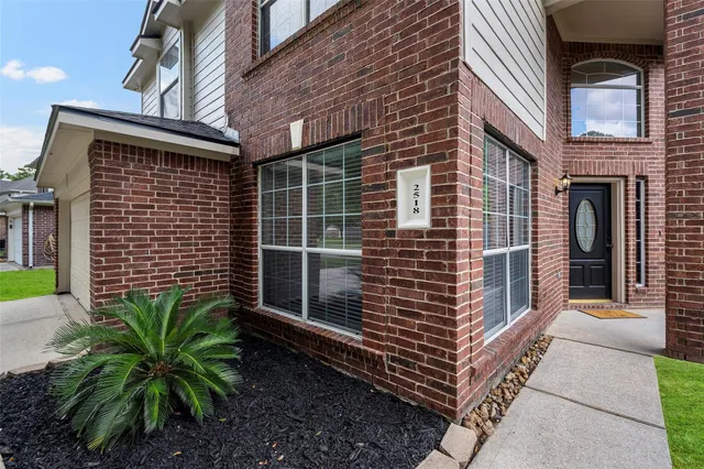 a backyard of a house with potted plants and brick wall