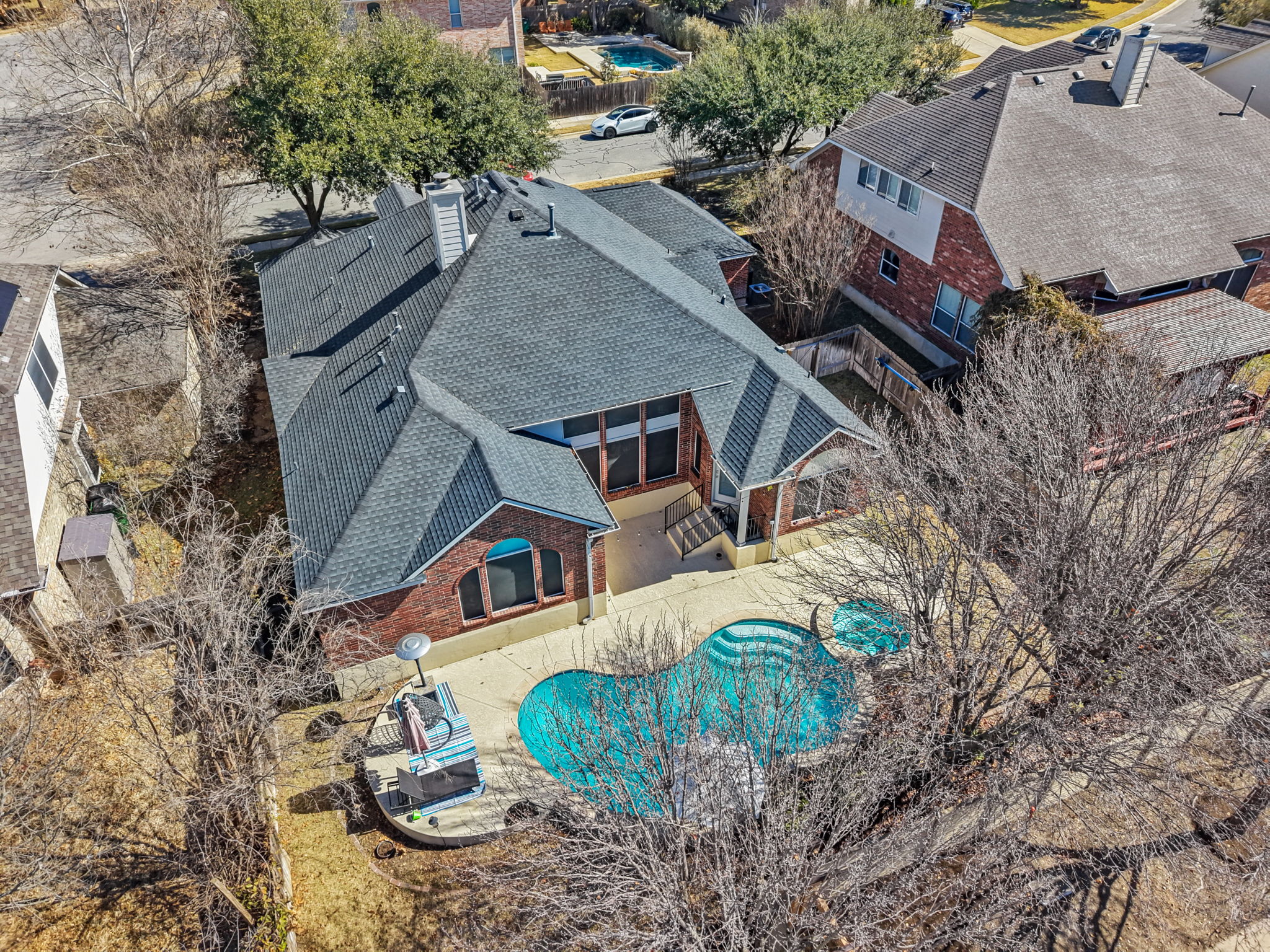 an aerial view of a house with a yard and table and chairs under an umbrella