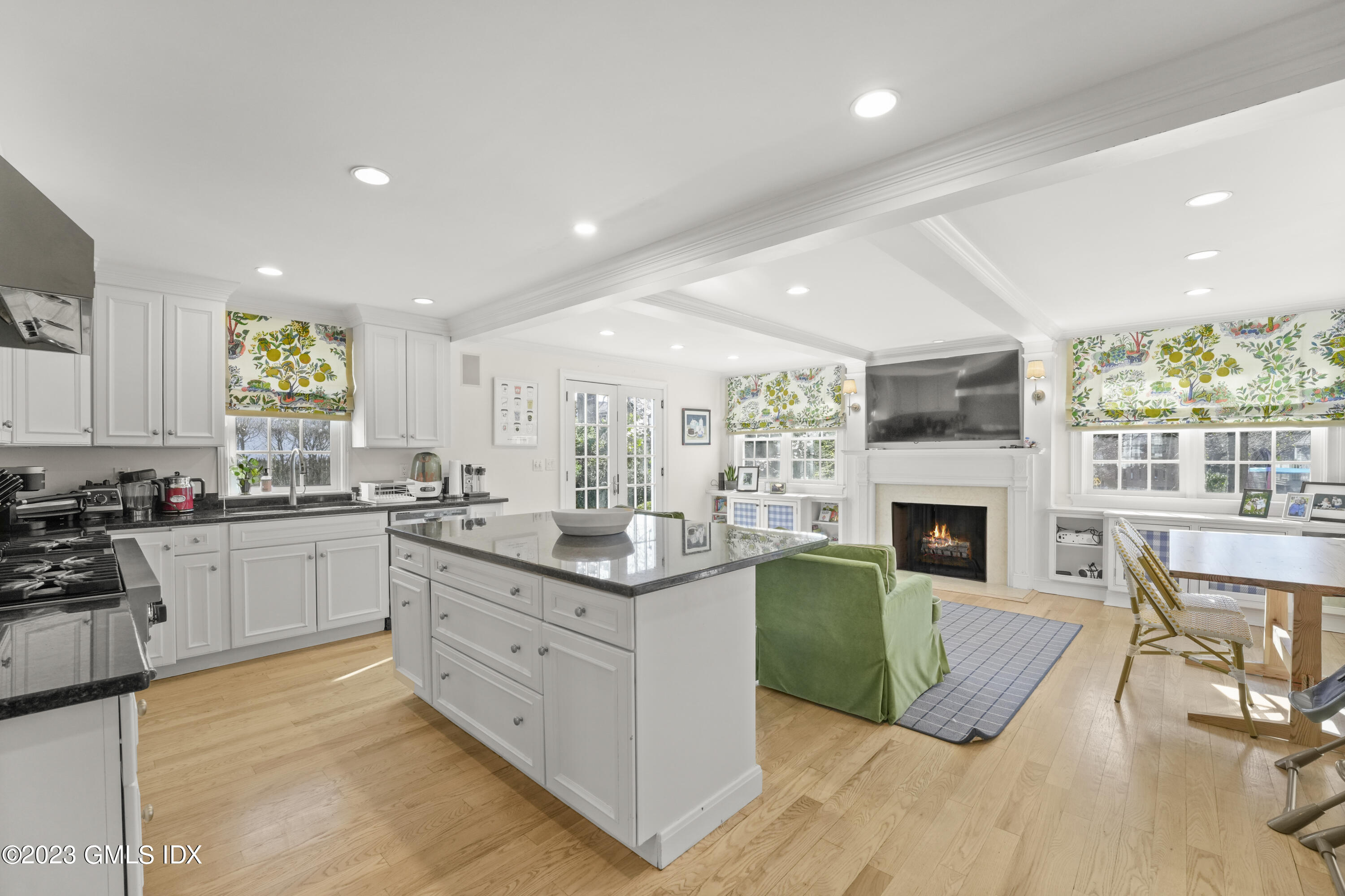 46 Terrace Avenue Riverside, CT 06878 - Photo 6 of 17 a open kitchen with granite countertop a stove top oven a sink dishwasher and a fireplace with wooden floor
