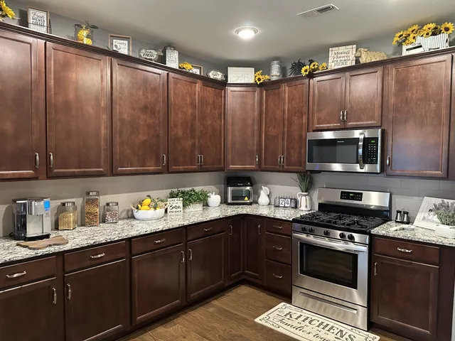 a kitchen with granite countertop wooden cabinets and stainless steel appliances