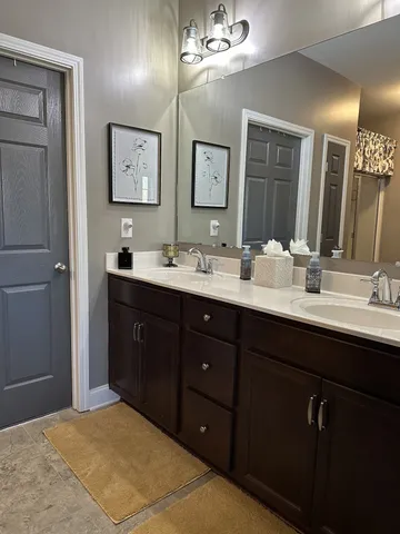 a bathroom with double vanity sink and a mirror