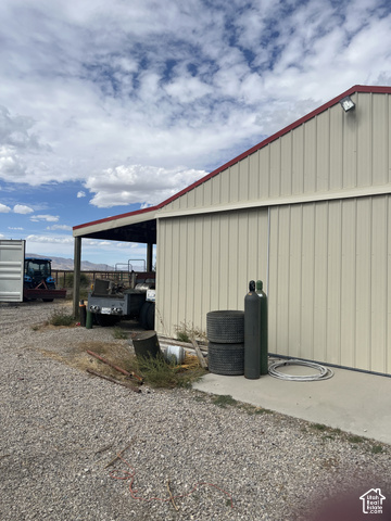 3839 Marshall Road Erda, UT 84029 - Photo 30 of 42 Metal-clad outbuilding with an attached covered area, a concrete pad, and a pitched roof with red trim