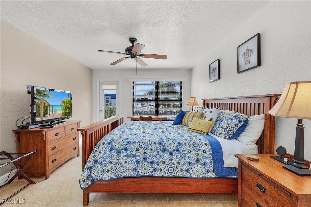 16641 Stringfellow Road, Unit 502 Bokeelia, FL 33922 - Photo 18 of 43 a bedroom with a large bed and a flat tv screen on dresser